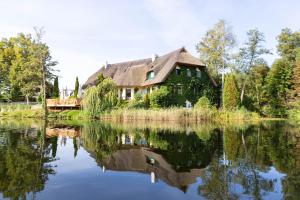 una casa sentada en la orilla de un lago en Fischhaus Am Kleinen Glubigsee en Wendisch Rietz