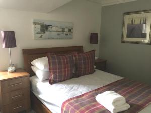 1 dormitorio con 1 cama con 2 almohadas en Urrard B&B, en Dingwall