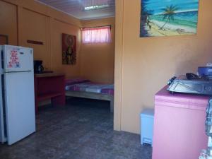 a room with a refrigerator and a table and a sink at Hotel One Love Puerto Viejo in Puerto Viejo