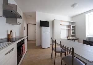 a kitchen with a table and chairs and a white refrigerator at I Dodici mesi - appartamento Primavera in Trento