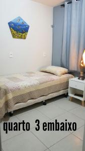 1 dormitorio con 1 cama y 1 mesa con lámpara en Cabo frio Beira mar Praia do Peró, en Cabo Frío
