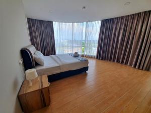 a bedroom with a bed and a large window at Bangi Perdana Hotel in Bangi