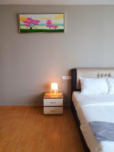 een slaapkamer met 2 bedden en een lamp op een nachtkastje bij Bangi Perdana Hotel in Bangi
