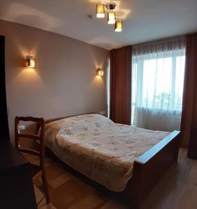 a bedroom with a bed in a room with a window at Hotel Turist in Chişinău