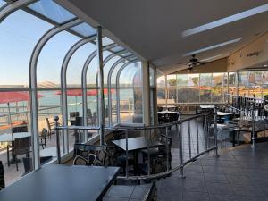 ein Restaurant mit Tischen und Stühlen auf einem Balkon in der Unterkunft Dockside Suites in Digby