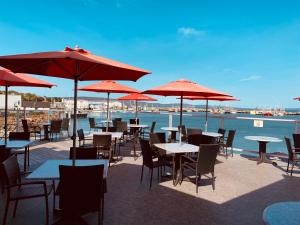a group of tables and chairs with red umbrellas at Dockside Suites in Digby
