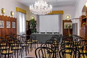 a room with chairs and a table and a chandelier at Hotel Don Abbondio in Lecco