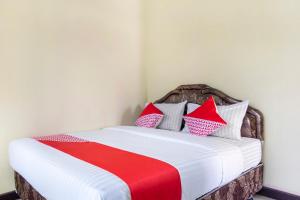 a bedroom with a bed with red and white pillows at SPOT ON 2950 Grand Suites Palace Syariah in Tjiandjur