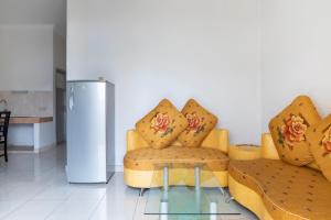 a living room with two chairs and a refrigerator at SPOT ON 2950 Grand Suites Palace Syariah in Tjiandjur
