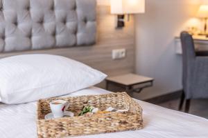 a tray with a cup of coffee on a bed at Hotel Podlasie in Białystok