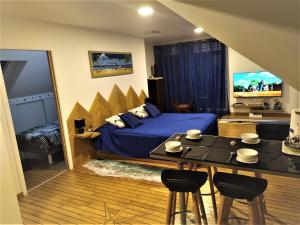 a bedroom with a bed and a table with chairs at LOGEMENT ATYPIQUE BIEN ETRE AU CŒUR DE LA NATURE in Quimper