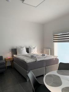 Bett in einem Zimmer mit 2 Stühlen und einem Tisch in der Unterkunft H&E Apartments Barntrup in Barntrup