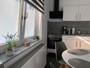 una cocina con armarios blancos y una mesa con sillas. en H&E Apartments Barntrup, en Barntrup