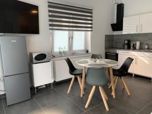eine Küche mit einem Tisch und Stühlen in einer Küche in der Unterkunft H&E Apartments Barntrup in Barntrup
