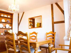 ein Esszimmer mit einem Holztisch und Stühlen in der Unterkunft Moss Cottage in Stratford-upon-Avon