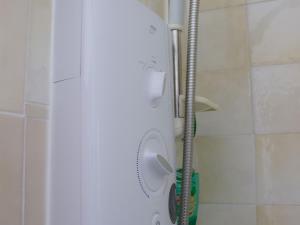 a shower with a white head in a bathroom at Moss Cottage in Stratford-upon-Avon