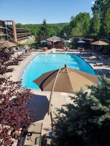 een groot zwembad met stoelen en een parasol bij New Hope Inn & Suites in New Hope