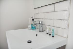 a bathroom sink with soap and toothbrushes on it at Cheltenham View Lodge in Cheltenham