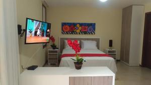 um quarto de hotel com duas camas e uma televisão de ecrã plano em Solar Pipa Flats em Pipa