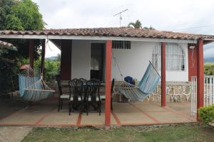 a porch with two hammocks and a table and chairs at Casa campestre arbelaez in Arbeláez +9 photos