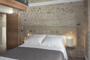 ein Schlafzimmer mit einem weißen Bett und einer Ziegelwand in der Unterkunft Dai Ventu in Pesaro