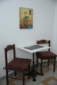 ローマにあるB&B Bel Amiのテーブルと椅子2脚、壁画
