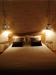 a bedroom with a large white bed with two lights at Quinta do Guerra in Boldrarias