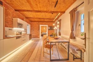 a kitchen with a wooden ceiling and a wooden table at Apartmány CHALLUPA in Horní Maršov