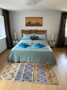 a bedroom with a bed with blue sheets and a rug at Ferienhaus-Aladdin in Garmisch-Partenkirchen