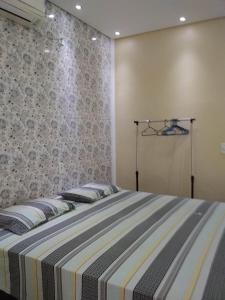 uma cama grande com almofadas num quarto em Pousada Chalé Morada em Valparaíso de Goiás