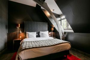 
a bedroom with a large bed and a large window at Hotel Bloemendaal in Bloemendaal
