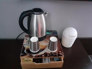a tea kettle on a table with a box of donuts at Citadel Hôtel in Calais