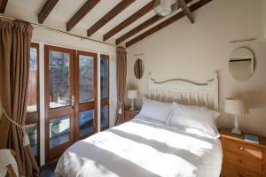 马沙姆Morton House and The Stable Block Masham - Adjoining holiday cottages for singles, couples and large groups的带白色床和窗户的卧室
