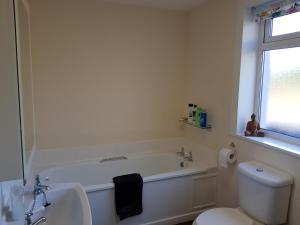 a white bathroom with a tub and a toilet at Glenduron-by-Sea in Saint Marys