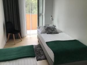 1 dormitorio con 1 cama, 1 silla y 1 ventana en Apartament Avanti z Klimatyzacją i Garażem en Toruń