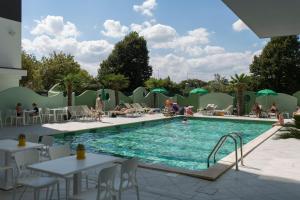 a pool at a hotel with people sitting around it at Nero D'Avorio Aparthotel & SPA in Rimini