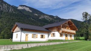 ein Haus auf einem Feld mit Bergen im Hintergrund in der Unterkunft Landhaus Wolfgang in St. Wolfgang