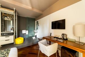 a hotel room with a desk and a tv at Hotel Ferrara in Ferrara