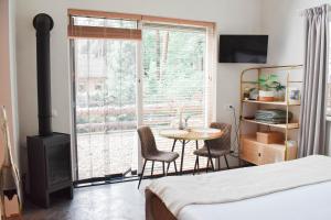 1 dormitorio con mesa, sillas y ventana en ForRest Suites, en Ermelo