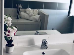 a bathroom with a sink and a mirror with flowers at CasaMatì Rome in Rome