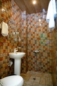 een badkamer met een toilet en een douche met een wastafel bij Primavera Guest House in Jerevan