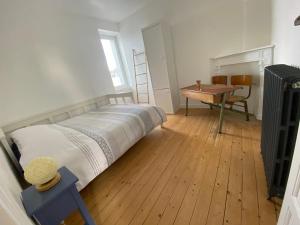 a bedroom with a bed and a table and a desk at Appartement lumineux Cancale, 80m2, 3 chambres. in Cancale