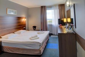 a hotel room with a bed with two towels on it at Hotel Tychy in Tychy