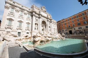 Una vista de la fuente de Trevi frente a un edificio. en Magenta Collection Crociferi 3, en Roma