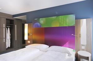 ein Schlafzimmer mit einem Bett mit einem großen Bildschirm darüber in der Unterkunft SeminarHotel am Ägerisee in Unterägeri