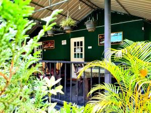 a green building with plants in front of it at Green Lantern in Ella