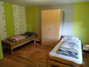 a bedroom with a bed and a cabinet in it at Ferienwohnung Frechenhausen - Marburg Biedenkopf mit 5 Zimmer - 2 Küchen - 2 Bad in Frechenhausen