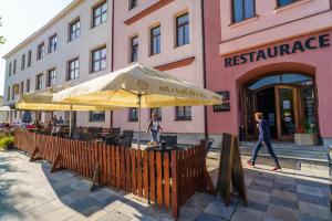a restaurant with tables and umbrellas in front of a building at Hotel U Labutě in Žďár nad Sázavou