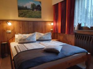 a bedroom with a bed with blue sheets and pillows at Gästehaus Hutweide in Bärenstein +38 photos