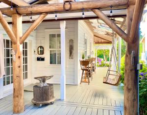 a porch with a wooden pergola and a swing at Princess and the Pea Hotel in Langley